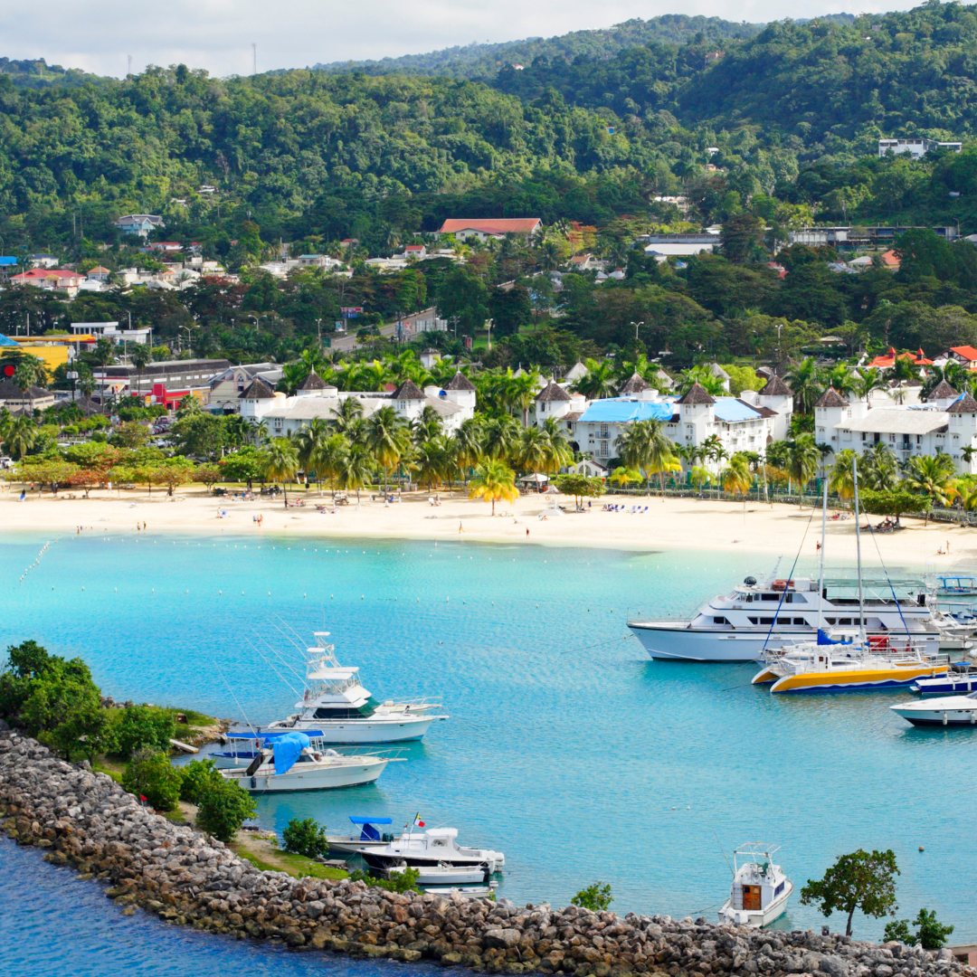 a picture showing a resort in Montego Bay Jamaica. Beautiful blue waters with yachts, boats and beach sand.