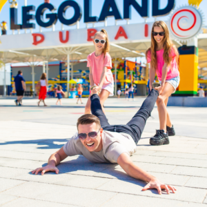 Two girls pulling dad at Dubai Legoland at Dubai Parks. and Resorts. Dubai, United Arab Emirates Thrilling Amusement Parks.