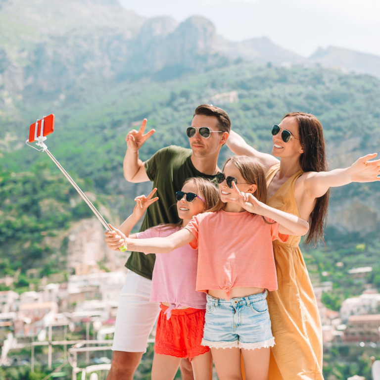 Parents and Kids Taking Selfie Photo Background Positano Town in Italy on Amalfi Coast